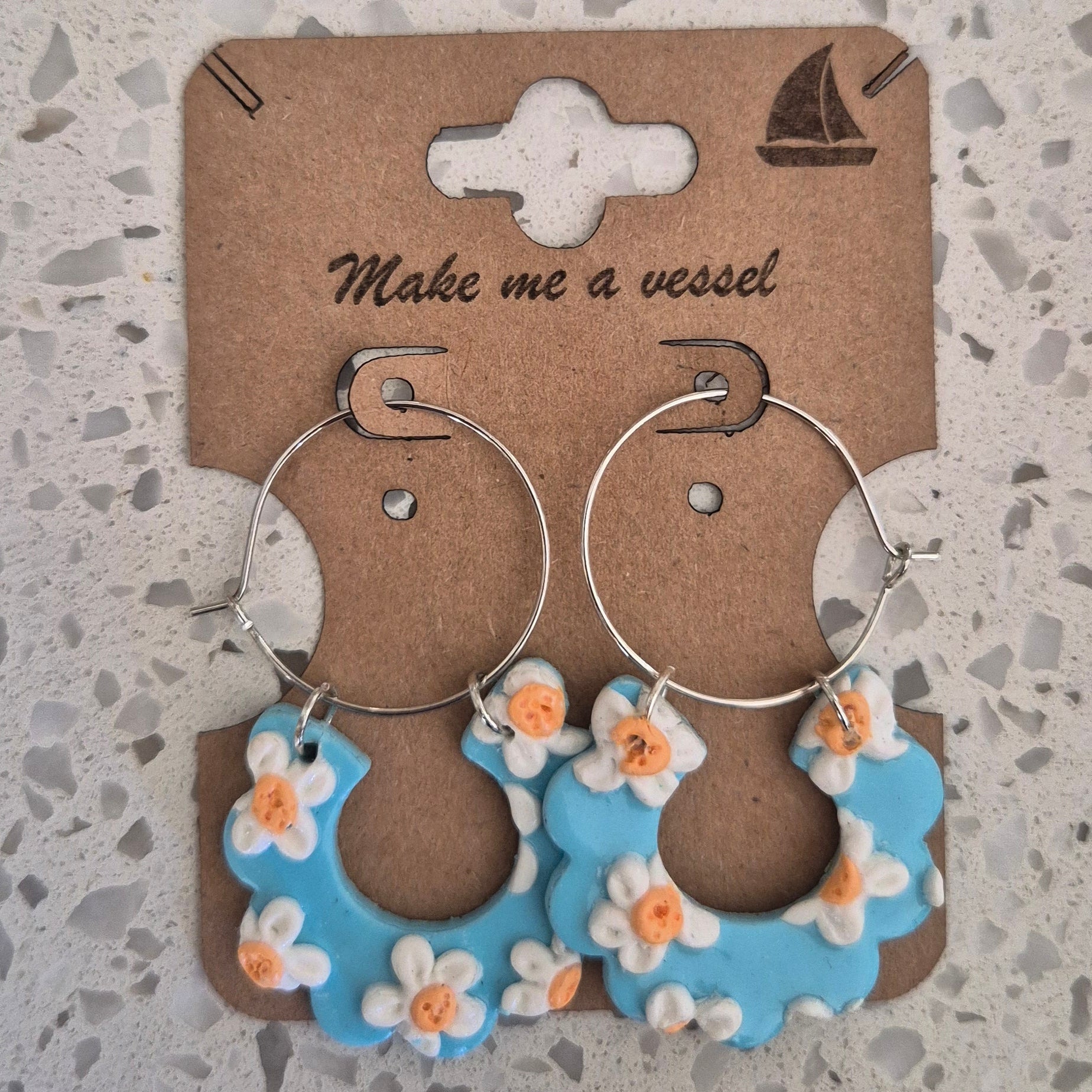 Silver hooped earrings with blue floral drops with smal flowers in white and yellow.