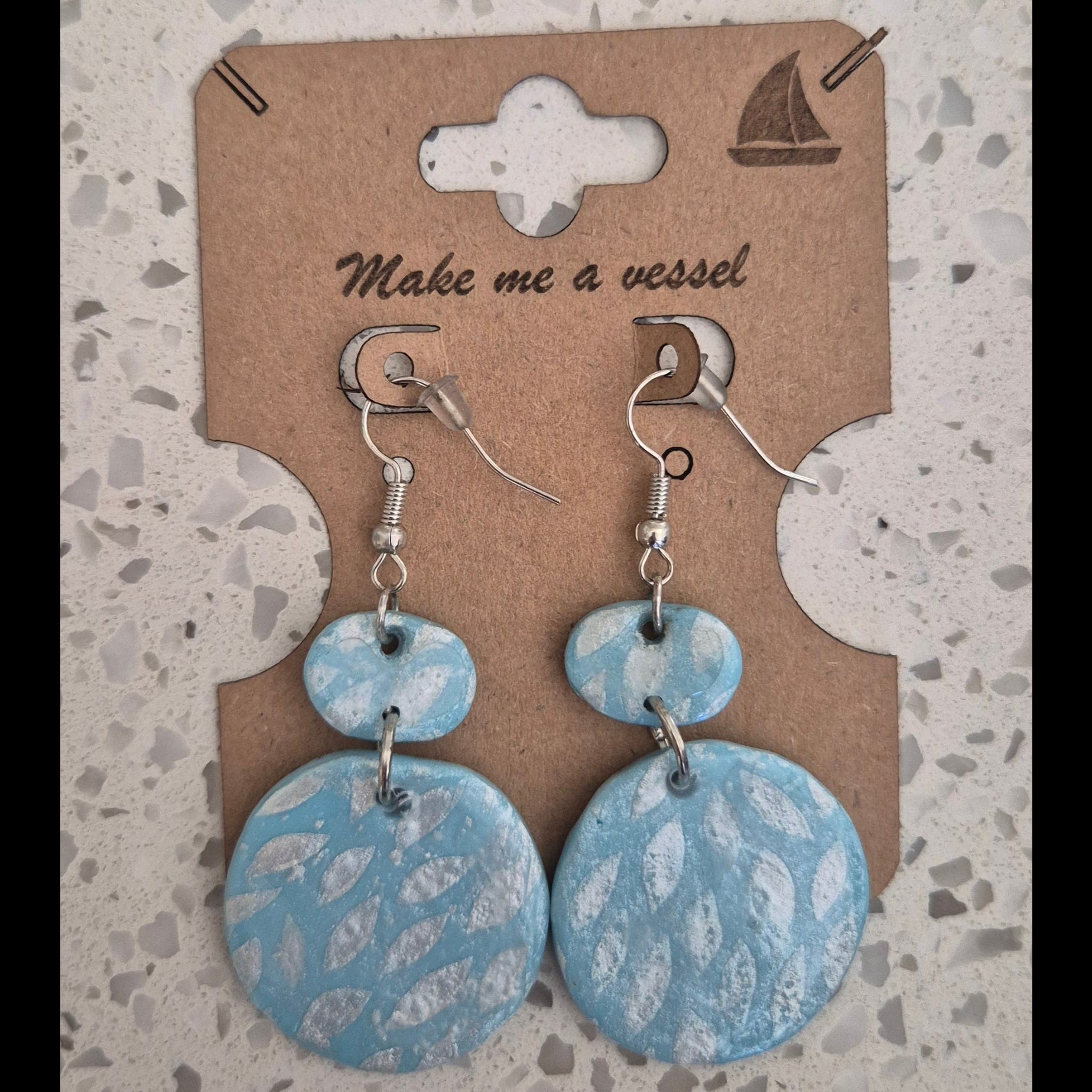 Blue circle earrings with silver leave imprints and silver finishing