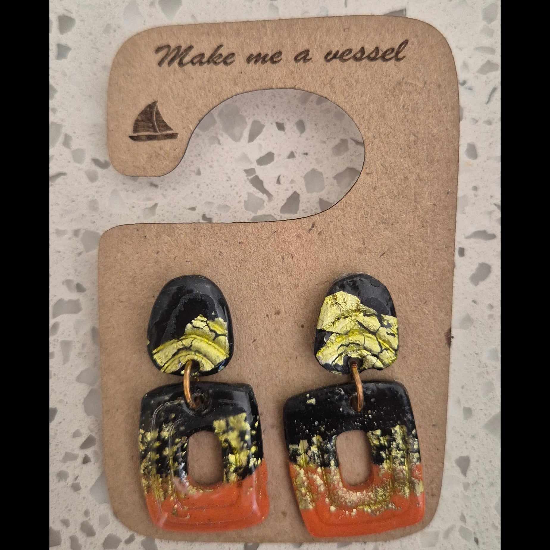 Geometric square earrings with black, gold and brown.