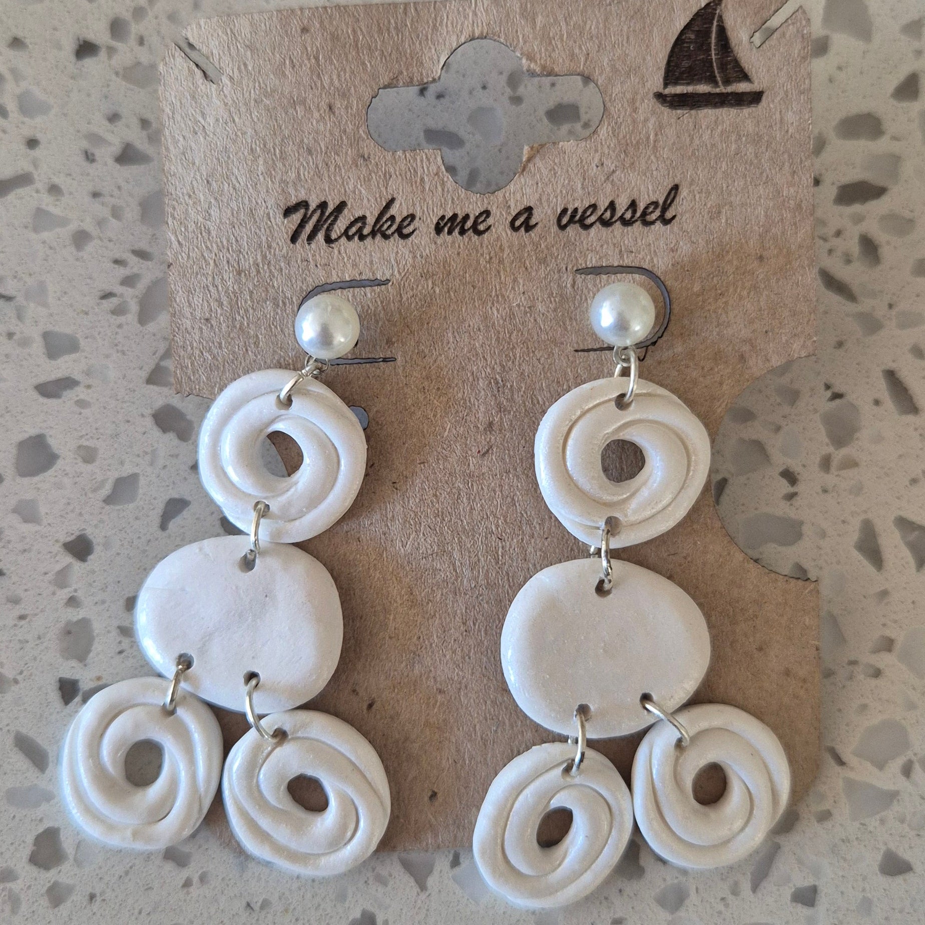 White beaded bracelet on a textured surface with a card